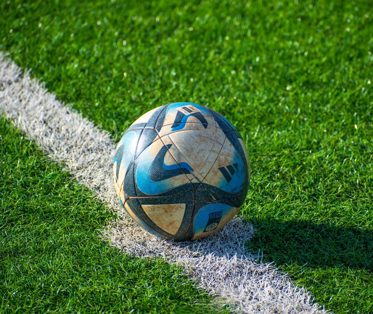 Crafting Captivating Headlines: Your awesome post title goes here A soccer ball rests on a vibrant green football field, ready for action.